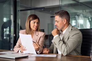 An image showing a business owner discussing figures with an accountant or reviewing financial information.