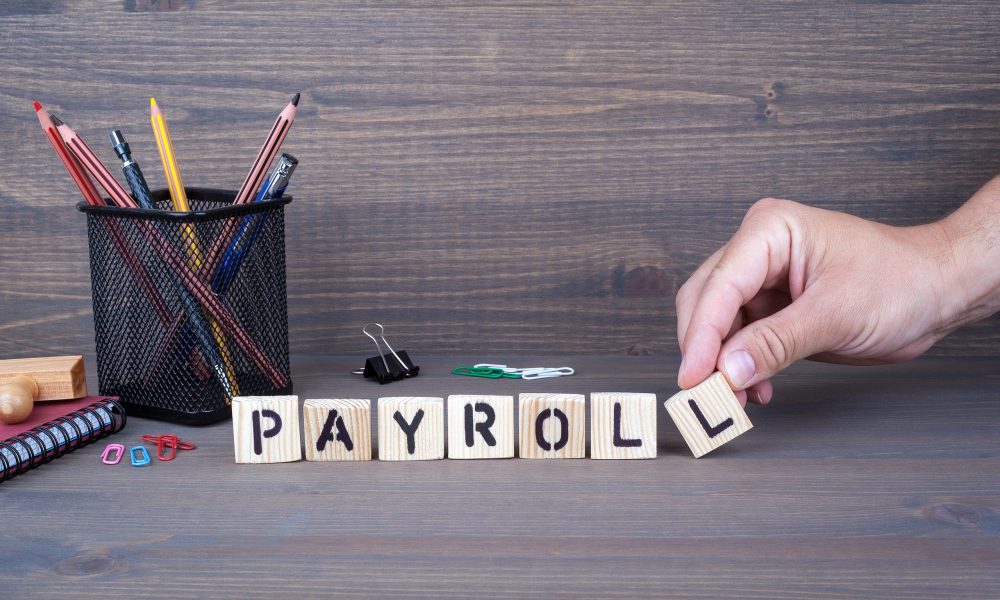 payroll. Wooden letters on dark background